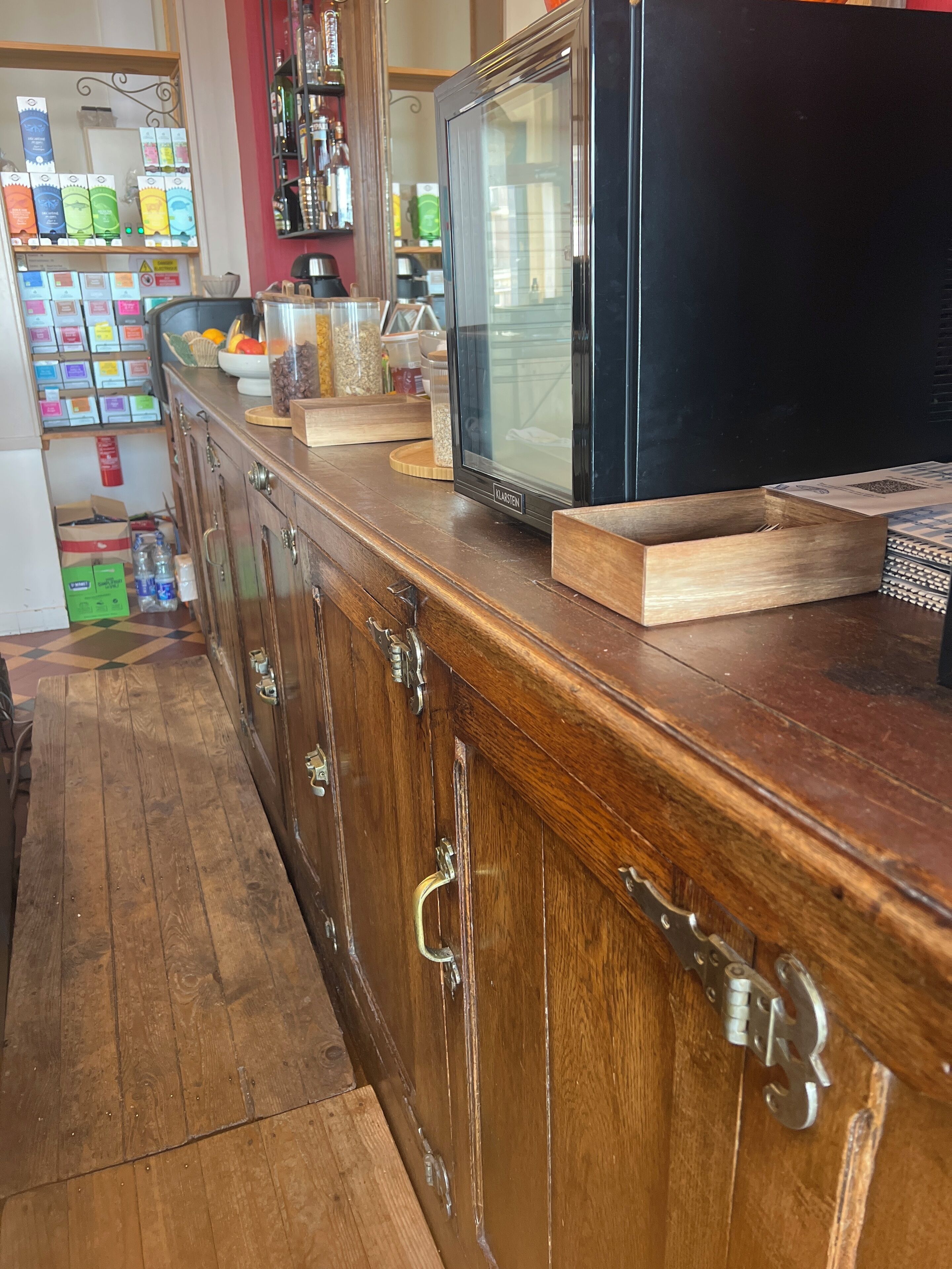 Una barra de madera con un televisor antiguo, un microondas y varios utensilios de cocina.