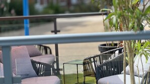 Outdoor seating with umbrellas, chairs, and a potted plant. - hôtel boutique la maison des galets (Saint-Valery-en-Caux)
