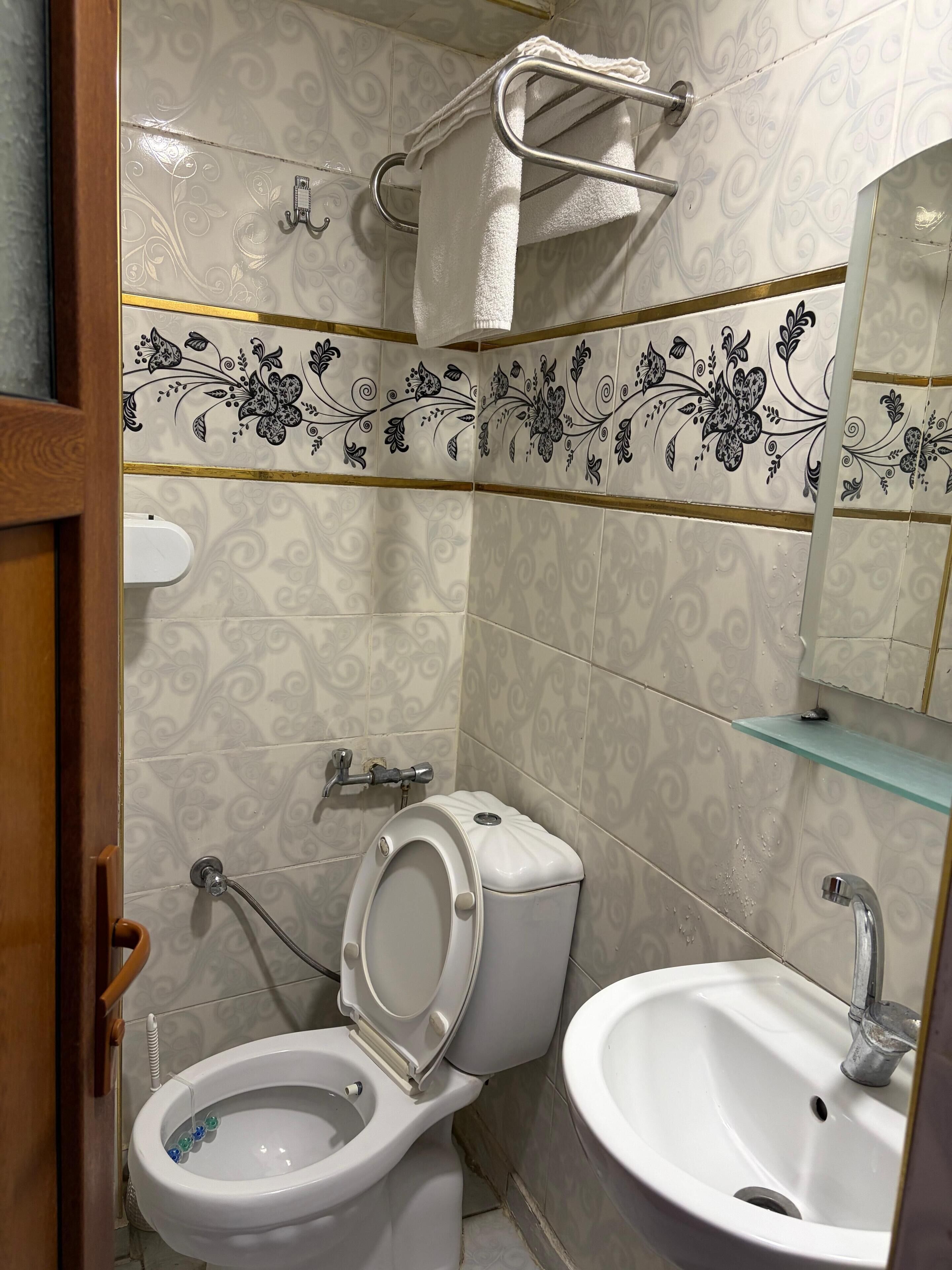 Un bagno con toilette, bidet, lavandino e portasciugamani.
