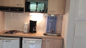 A compact kitchen with a microwave, coffee maker, and a dishwasher. - 4 pers. apartment with quiet balcony, pool access (Besse-et-Saint-Anastaise-Super Besse)