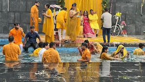 A group of people in a swimming pool with a stage and floral decorations in the background. - SK PREMIUM PARK SONIPAT (Ganaur)