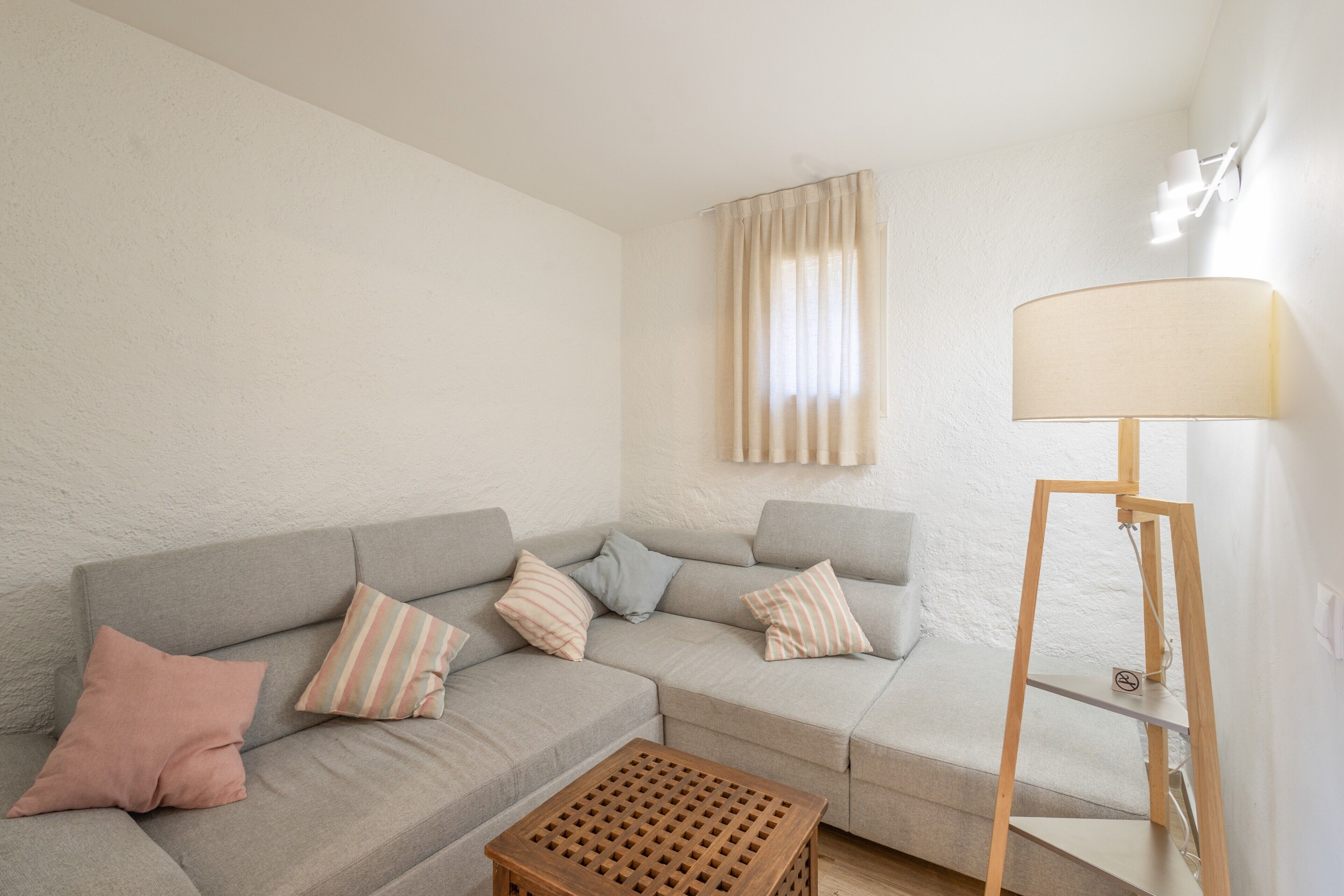 A living room with a grey sofa, a wooden coffee table, and a floor lamp.