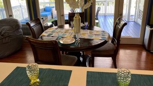 Un área de comedor con una mesa redonda, sillas y vista a la terraza exterior.