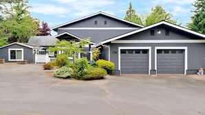 Uma casa moderna de dois andares com garagem, cercada por um jardim bem cuidado.