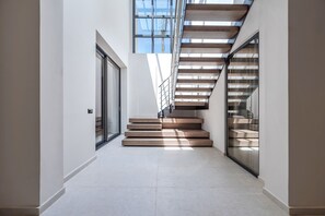 A modern interior with a staircase, glass doors, and a view of the sky. - Nysa Luxury villa 3,Private pool,Near Hersonissos (Heraklion)