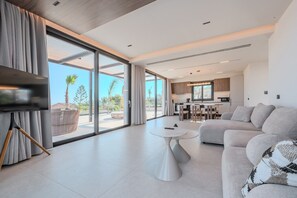 Una sala de estar moderna con un sofá, una mesa de centro y un televisor.