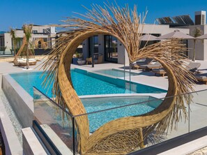 A modern pool area with a unique circular wicker structure, lounge chairs, and a clear blue pool. - Nysa Luxury villa 4, Private pool, Near Hersonissos (Heraklion)