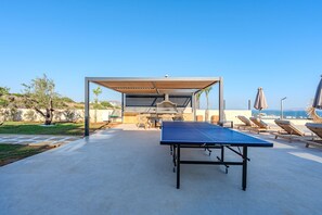 An outdoor table tennis table with a canopy, lounge chairs, and a barbecue area. - Nysa Luxury villa 4, Private pool, Near Hersonissos (Heraklion)