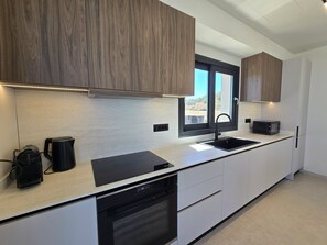 A modern kitchen with wooden cabinets, a black sink, and a built-in dishwasher. - Nysa Luxury villa 4, Private pool, Near Hersonissos (Heraklion)