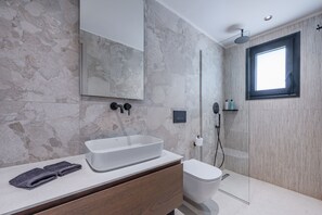 A modern bathroom with a large mirror, a rectangular sink, a toilet, and a glass shower enclosure. - Nysa Luxury villa 6, Private pool, Near Hersonissos (Heraklion)