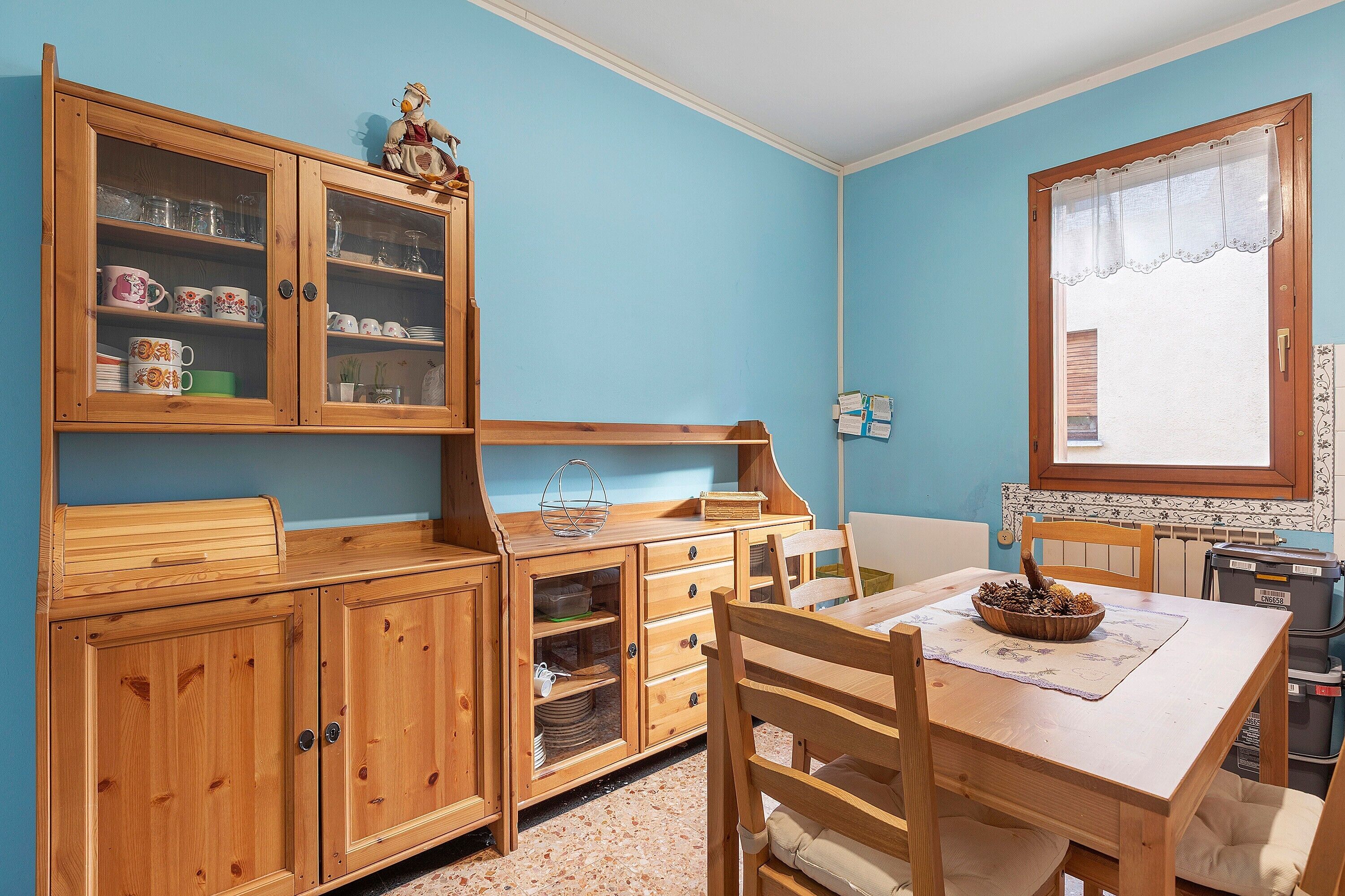 Una cocina de madera con armarios, una mesa de comedor y sillas.