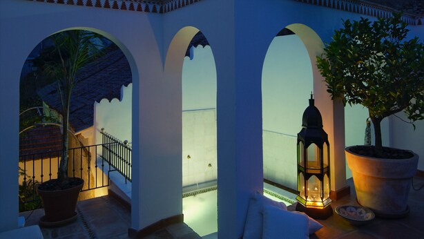 A courtyard with arches, a lantern, and a potted tree. - Andalusian Villa with moorish touch and "Hammam" pool (Granada/Albuñol/La Rábita)