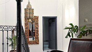 A living room with a bowl of fruit, a chair, a mirror, and a staircase. - Andalusian Villa with moorish touch and "Hammam" pool (Granada/Albuñol/La Rábita)