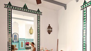 A room with a ceiling fan, a sofa, a chair, a patterned rug, and a decorative mirror. - Andalusian Villa with moorish touch and "Hammam" pool (Granada/Albuñol/La Rábita)