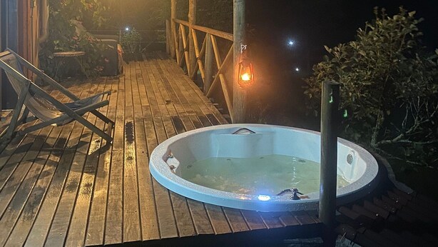 A wooden deck with a hot tub, a pergola, and a lantern. - Sítio Solar di Stella (Itatiaia)