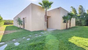 Een modern huis met twee verdiepingen, een plat dak, een klein voortort en een verzorgd gazon met stapstenen naar de ingang.