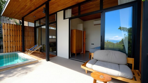 A modern outdoor living area with a pool, a sofa, and a chair. - Yume 17 Sea View Villas (Ko Pha-ngan)
