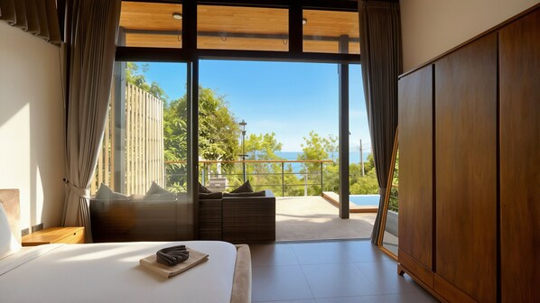 Ein Schlafzimmer mit einer großen Glasschiebetür, die auf einen Balkon mit Meerblick führt.