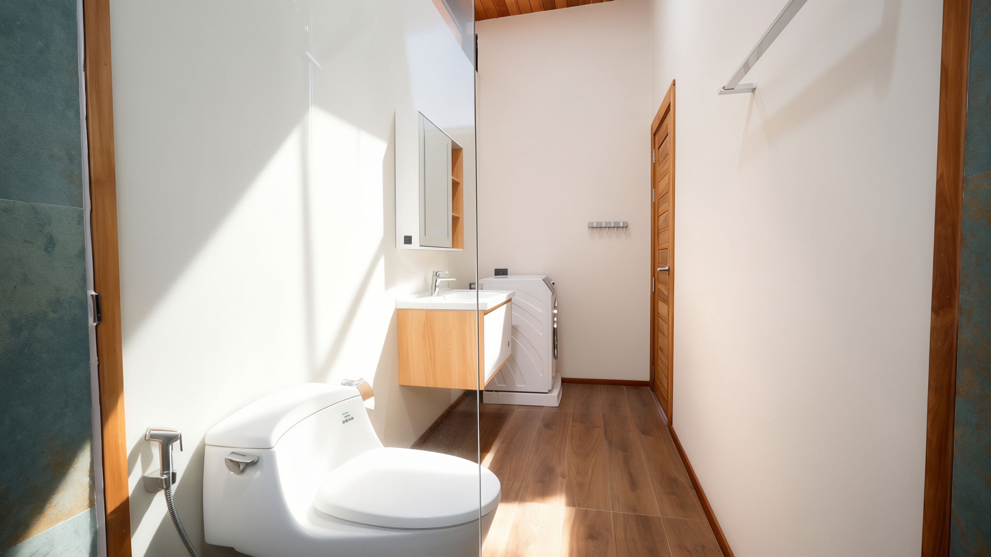 A modern bathroom with a toilet, sink, and mirror.