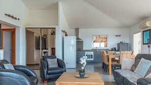 Una sala de estar moderna con un sofá, una mesa de centro y un comedor con sillas y una mesa.
