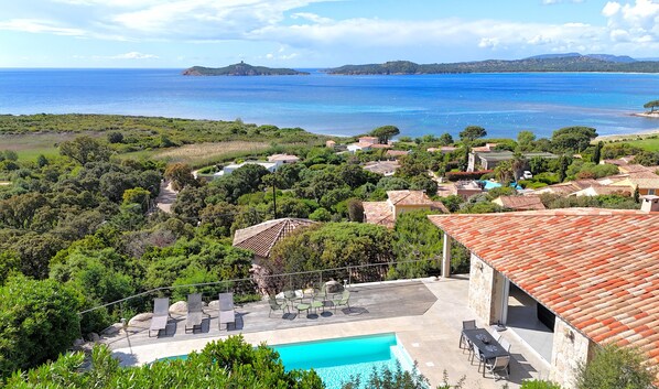 A coastal villa with a swimming pool, outdoor seating, and views of the sea and hills. - Villa Bella Vista Di Pinarello (Zonza)