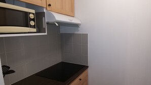 Eine Küche mit Mikrowelle, Herd und Schrank.