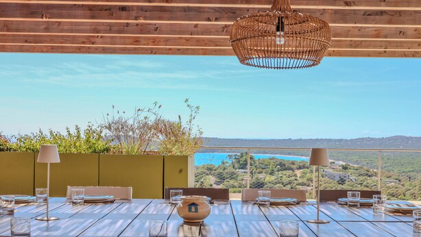 A dining table set for four with a view of the sea and hills in the background. - Villa Ghjiseppina Di Pinarello (Porto-Vecchio)