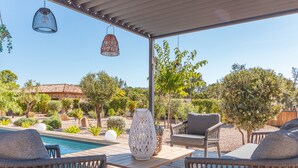 A wooden deck with outdoor furniture, a pool, and a pergola with hanging lights. - Villa Felicita di Lecci (Lecci)