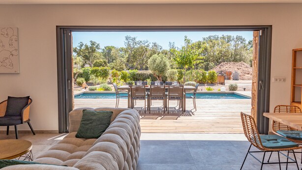 A modern living room with a large sliding glass door leading to a pool area. - Villa Felicita di Lecci (Lecci)