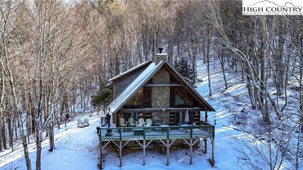 A cabin with a porch and outdoor seating area surrounded by trees. - 3-bedroom cabin in serene Banner Elk on 8 Acres with Mountain View’s (Banner Elk)