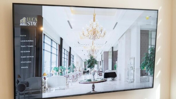 A spacious lobby with a chandelier, comfortable seating, and a large window. - Luca Stay Duomo Visconti Suites (Milan)