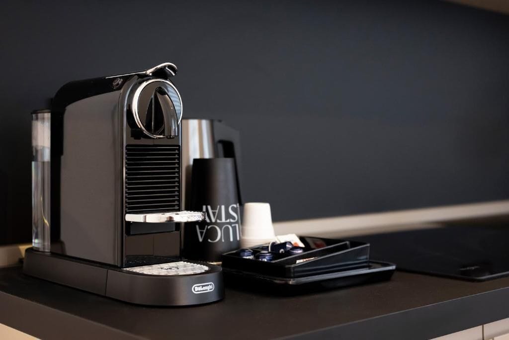 Eine Kaffeemaschine mit Tassenhalterung und Tablett auf einer dunklen Arbeitsplatte.