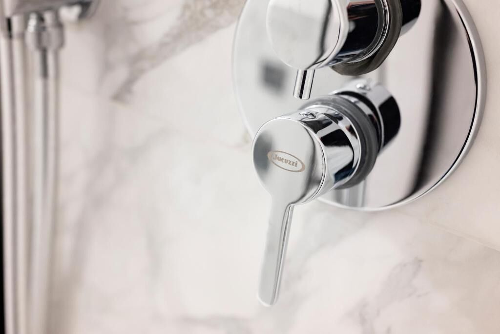 A modern bathroom with a chrome faucet and a visible brand name.