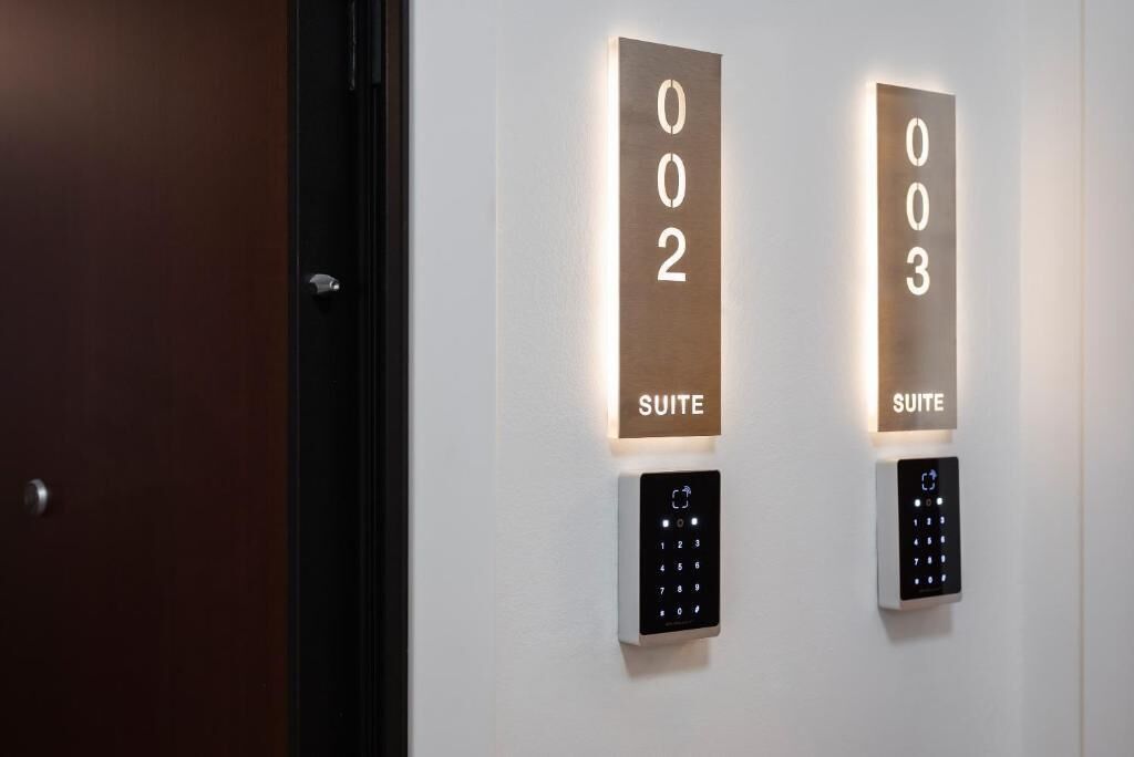 Two illuminated suite numbers, 002 and 003, each with a corresponding keypad below.