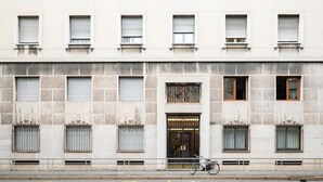 A building with multiple windows, some with shutters, and a bicycle parked in front. - Luca Stay Duomo Visconti Suites (Milan)