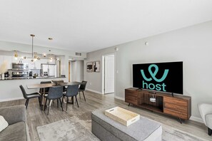 Ein modernes Wohnzimmer mit Essbereich, einer Küche und einem Fernseher, der das Wort "host" anzeigt.