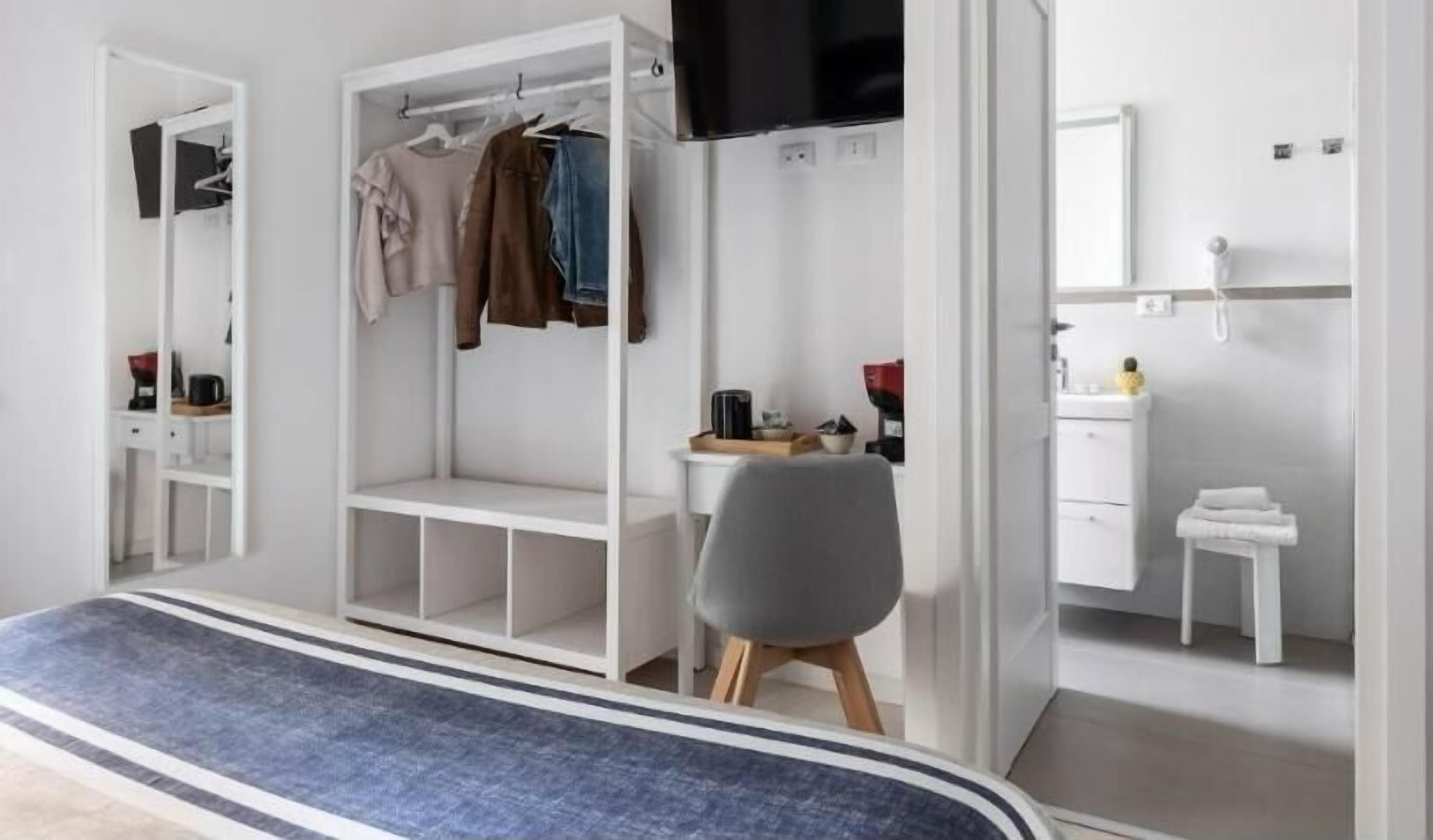 Een moderne slaapkamer met een bed, een kledingkast, een bureau en een televisie.