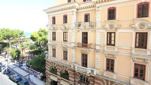 A multi-story building with classical architecture, featuring balconies and large windows.