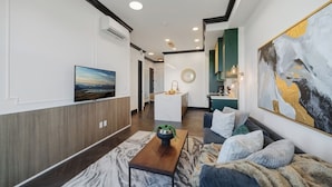 A modern living room with a sofa, coffee table, and artwork.