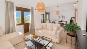 A modern living room with a beige sofa, a glass coffee table, and a dining area in the background. - Villa Mima Pool Retreat (Lovreć)