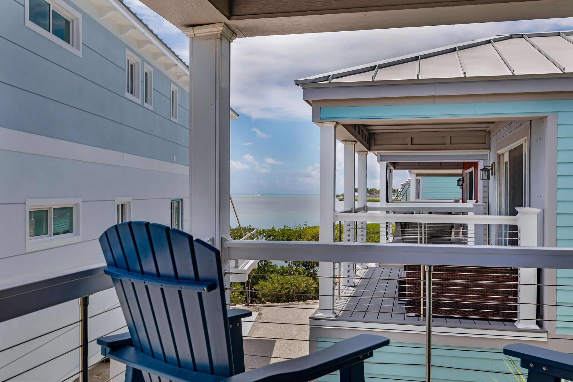 A balcony with a view of a building and the ocean.