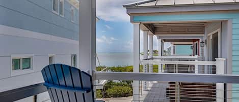 A balcony with a view of a building and the ocean.