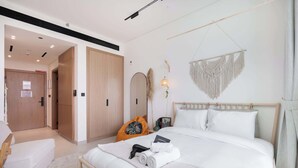 Ein modernes Hotelzimmer mit einem großen Bett, einem Holzschrank, einer Sitzecke und einem Wandbehang aus Makramee.