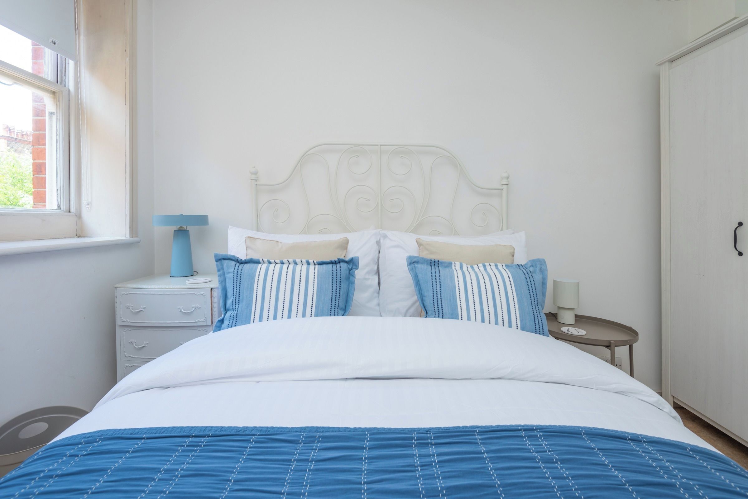 Una camera da letto con un letto, un comodino, una lampada e un armadio.