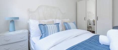 Tabla de planchar con plancha, internet y ropa de cama