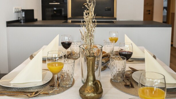 A modern kitchen with a central island, equipped with a microwave and oven. - Alpine Apartment With View & Garden (Wildschönau)