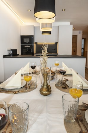 A modern kitchen with a central island, equipped with a microwave and oven. - Alpine Apartment With View & Garden (Wildschönau)