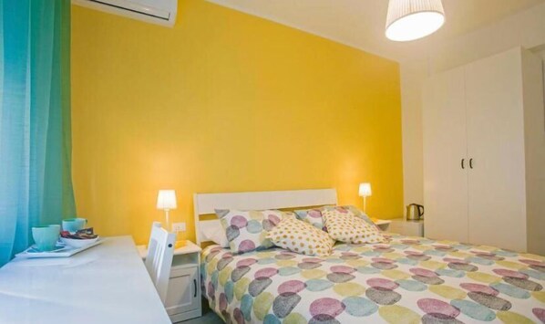 A bedroom with a bed, two bedside tables, a nightstand, and a wardrobe.