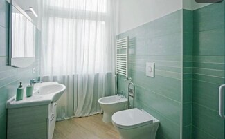 Un bagno con un lavandino bianco, un bidet e un water.