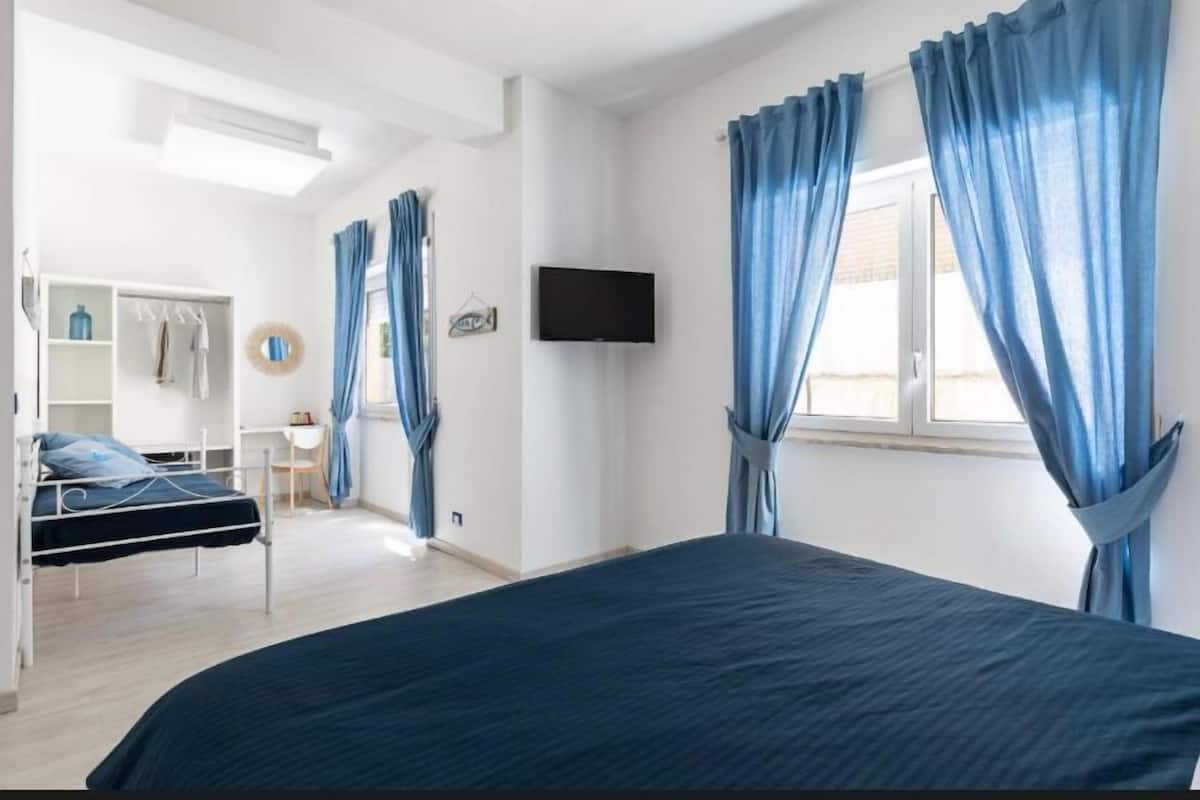 Un dormitorio con cama, televisión y armario.